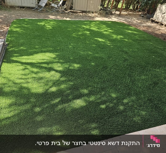 דשא סינתטי ירוק בגינה עם שביל עץ בצד